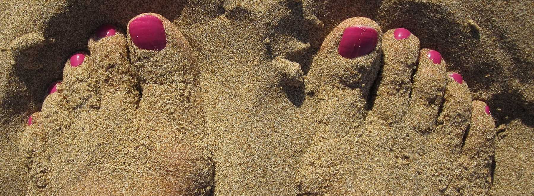 lackierte Fußnägel, Füße im Sand