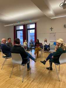 Lehrende sitzend bei einer Diskussion