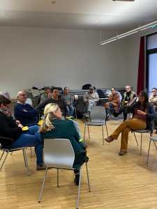 Lehrende sitzend bei einer Diskussion