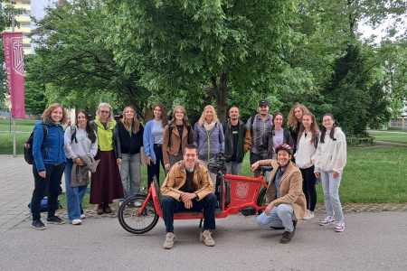 Studierende und Lehrender mit Lastenrad