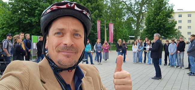 Lehrender mit erhobenem Finger bei der Fahrradsegnung