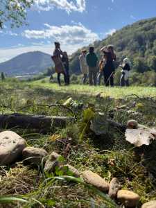 Studierendengruppe mit Lehrender in der Natur